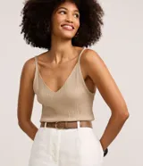 Musculosa de punto canelado color beige con hilo metalizado, escote en V y tirantes finos.