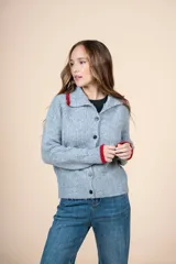 Cárdigan de punto gris con cuello camisero y detalles en rojo en cuello y puños. Cierre frontal con botones.