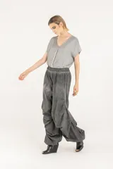 Pantalón amplio de popelina de algodón y satén de viscosa, en tono gris con efecto de teñido en frío. Presenta cintura elastizada, diseño de pierna ancha con frunces laterales y cordón de ajuste en el ruedo que permite fruncirlo en los tobillos.