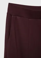 Pantalón de corte recto y pernera ancha, color bordó, con cintura elástica y bolsillos laterales.