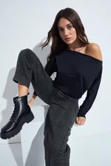 Top de manga larga con escote bote amplio, diseñado para usar ligeramente caído sobre los hombros. Presenta una silueta entallada y tejido liso, liviano y adaptable al cuerpo.