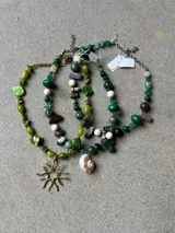 Collar de piedras naturales en tonos verdes con dije colgante de bronce con diseño orgánico.