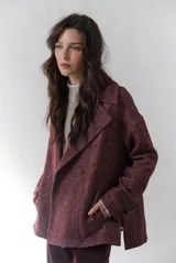 Chaquetón de lana color bordó con diseño de espiga y motas blancas. Tiene solapa, doble abotonadura frontal, mangas largas con detalle de correa y hebilla en los puños.