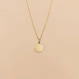 Collar de oro amarillo 18K compuesto por una cadena fina y un dije circular liso diseñado para grabar.