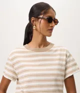 Remera de mujer Marfinno de manga corta, con diseño a rayas horizontales en tonos blanco y beige, y cuello redondo acanalado en color tostado.