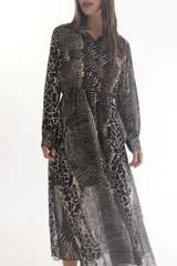 Vestido midi camisero con estampado animal print, de manga larga y cuello camisero. Tiene dos bolsillos con solapa en el pecho y cintura elastizada.