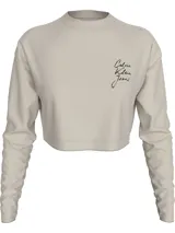 Remera cropped color beige de algodón, con cuello redondo y mangas largas. Presenta el logo de Calvin Klein Jeans estampado en el pecho.