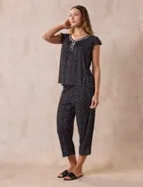 Conjunto de pijama marca René Rofé, compuesto por una remera de escote en V con botones y un pantalón capri con cintura elastizada, ambos en tejido soft estampado con motivos florales en tonos celeste y blanco.