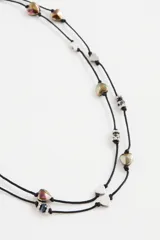 Collar doble de cordón negro con dijes de corazones metálicos y cuentas de cristal facetado.