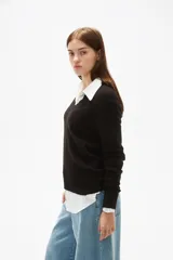Sweater de tejido de punto color negro, con cuello en V y diseño holgado de manga larga.