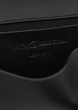 Cinturón de cuero vacuno negro con hebilla metálica cuadrada y monedero o cartuchera extraíble colgante con cierre de solapa y broche a presión.