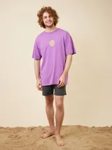 Short de baño color beige, de corte volley, con cintura elástica y cordón ajustable. Presenta un pequeño logo bordado en la parte inferior de la pierna izquierda.