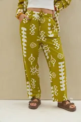 Pantalón color verde lima con estampado abstracto en blanco, de corte recto y tiro alto con cordón ajustable en la cintura.