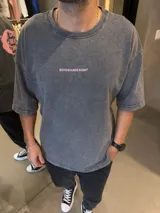 Remera de algodón pesado con corte oversize y efecto lavado. Presenta un diseño gráfico estampado en la espalda con letras en color rosa sobre un círculo irregular del mismo tono.