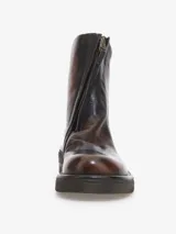 Bota corta de cuero bovino, color negro con efecto desgastado o metalizado grisáceo. Presenta cierre lateral con tirador y suela gruesa de goma con relieve.