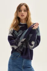 Sweater de tejido de punto con diseño jacquard abstracto en tonos azules y detalles brillantes en lurex. Presenta cuello redondo, mangas largas y puños y ruedo acanalados.
