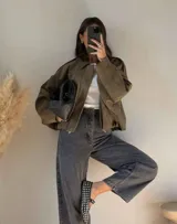 Campera bomber de corte oversized con efecto gamuza en color verde oliva. Presenta cuello clásico, cierre frontal y hombros estructurados con un diseño minimalista y relajado.