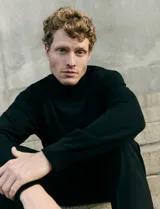 Polera de cuello alto y manga larga, confeccionada en tejido de punto fino, con un diseño minimalista y ajuste clásico.