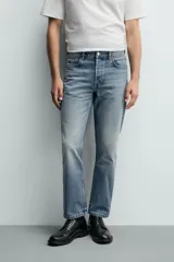 Jeans regular fit de denim de algodón en color gris con efecto lavado, tiro medio, diseño de cinco bolsillos y cierre frontal con botones.