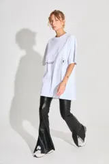 Remerón de corte oversized confeccionado en algodón, con cuello redondo y mangas cortas. Presenta estampados gráficos en color negro en la parte frontal.