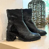 Botas de cuero negro con caña media, cierre lateral con cremallera, puntera redondeada y tacón cuadrado con textura de cocodrilo.