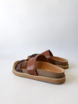 Sandalias bajas de cuero marrón con estampado animal print en las tiras.