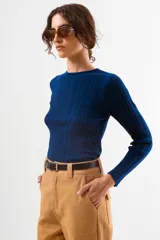 Top de tejido liviano con textura acanalada, de calce al cuerpo y manga larga con cuello redondo.