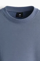 Buzo de cuello redondo confeccionado en mezcla de algodón con interior cepillado. Presenta diseño de hombros caídos y terminaciones acanaladas en puños y ruedo.