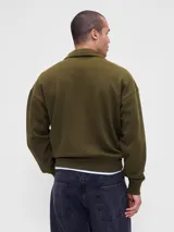 Buzo de algodón con cuello alto y cierre frontal parcial, de manga larga con puños y ruedo acanalados.