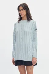 Buzo negro de tejido de ochos, con cuello redondo y diseño oversized de corte largo y amplio con tajos laterales.