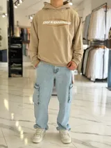 Hoodie de corte boxy fit color gris, con capucha y estampado frontal con la leyenda "Duxon Creative Studios".