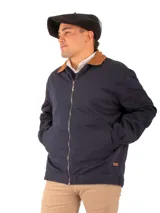 Campera azul marino de gabardina de algodón con cuello marrón, cierre metálico y bolsillos laterales. Forrada con paño y puños ajustables.