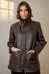 Campera reversible de cuero ovino color marrón oscuro, con cuello alto y cierre frontal. Presenta bolsillos frontales y diseño abrigado.