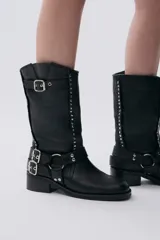 Bota de caña media color marrón de cuero con hebillas y tachas plateadas.