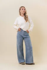 Jean wide leg de tiro alto con calce relajado y pierna amplia. Confeccionado en denim con leve desgaste, cuenta con cintura definida con presillas, bolsillos clásicos y cierre frontal con botón metálico.