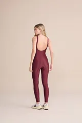 Jumpsuit largo de una pieza, color bordó, con diseño ajustado, escote redondo y tirantes anchos. Confeccionado en tejido con acabado satinado y elástico.