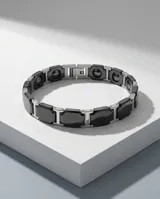 Pulsera de eslabones combinados en acero inoxidable y cerámica negra, con diseño moderno y cierre oculto.