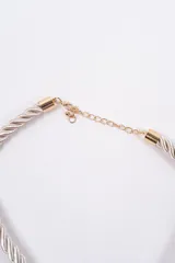 Set compuesto por un collar de cordón trenzado negro con dije central en forma de concha dorada y un par de aros a juego con diseño de concha dorada.