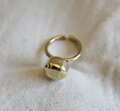 Anillo dorado con dije irregular con forma de piedra.
