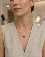 Collar de plata 925 con cadena fina y dije redondo tipo punto de luz, con circonia central en color violeta.