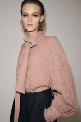 Camisa de algodón con estampado de rayas verticales, cuello subido con lazada frontal, manga larga abullonada y puños ajustados.