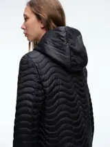 Campera negra con diseño acolchado de ondas horizontales, cierre frontal completo, capucha integrada y mangas largas.