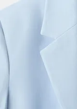Blazer celeste de corte recto, con cuello de solapa con muesca, manga larga, bolsillos laterales con solapa y cierre frontal de un botón.