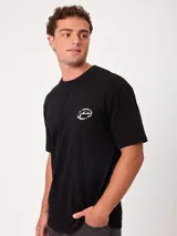 Remera Rusty de manga corta, color blanco, con ajuste holgado y gran estampa gráfica en la espalda de un mago surfeando entre olas.