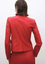 Chaqueta tipo blazer de corte recto y diseño estructurado, color rojo intenso. Presenta cuello con solapas de muesca, cierre frontal de dos botones, mangas largas con puños abotonados y dos bolsillos laterales con solapa.