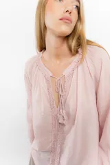 Blusa celeste de algodón con escote en V con lazos y mangas largas abullonadas con puños elásticos.