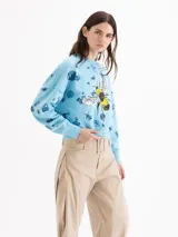 Buzo celeste de algodón con estampado floral y gran diseño de abeja en el frente. Presenta mangas largas y cuello redondo.