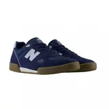 Championes urbanos New Balance modelo 600, color azul marino con detalles en celeste y suela de goma color caramelo. Confeccionados en una combinación de gamuza y malla, presentan el logo 'N' característico en los laterales.