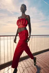 Pantalón capri de vestir color rojo, de corte slim, tiro alto, con pinzas delanteras, bolsillos laterales y falsos bolsillos traseros.