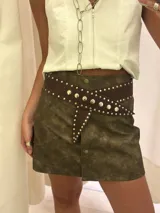 Faja de cuero marrón oscuro, forrada, con diseño cruzado y remaches metálicos dorados a lo largo de los bordes. Se ajusta con broches a presión.